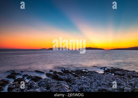 Sonnenuntergang über der Meeresbucht im Dorf Rogoznica, ein beliebtes Touristenziel an der dalmatinischen Küste der Adria in Kroatien, Europa. Stockfoto