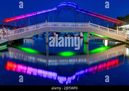 Beleuchtete Brücke am Abend im Dorf Rogoznica, ein beliebtes Touristenziel an der dalmatinischen Küste der Adria in Kroatien, Europa. Stockfoto
