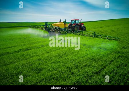 Luftaufnahme von landwirtschaftlichen Traktor Pflügen und Spritzen auf dem Feld. Stockfoto