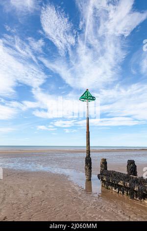 Hölzerne Groyne und hohes Ende der Groyne-Markierung am Sandstrand gegen Cirrus Wolke Himmel Hintergrund Stockfoto