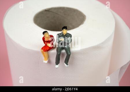 Ein Paar Figuren, die auf einer Rolle Toilettenpapier sitzen Stockfoto