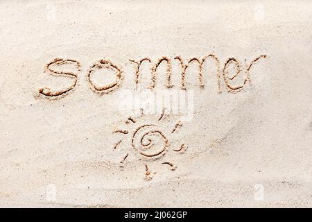 Handschriftliche Worte „versommern“ auf Sand am Strand Stockfoto