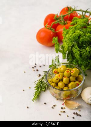 Schöne Komposition. Grüne Oliven, ausgesuchte Gemüse und Kräuter. Salatzutaten. Vitamine, Antioxidantien, gesunder Lebensstil, Ökologie, Ernährung. Stockfoto