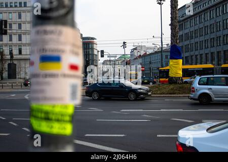 Warschau, Polen. 16. März 2022. Ein Blick auf einen Baum, der mit einer ukrainischen Flagge gehüllt ist. Ukrainische Bürger fliehen nach Polen, um der Gewalt vor der russischen Invasion zu entgehen. Für viele ist der Warschauer Hauptbahnhof eine Haltestelle. (Foto von Ty O'Neil/SOPA Images/Sipa USA) Quelle: SIPA USA/Alamy Live News Stockfoto