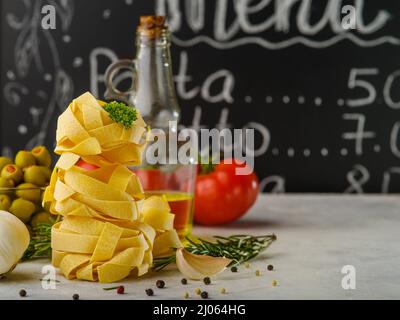 Schöne Komposition. Italienische Pasta, Gemüse, Kräuter, Olivenöl Flasche. Das Konzept ist italienische Küche Rezepte. Restaurant, Hotel, Kochbuch, Werbung Stockfoto