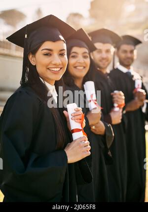 Es ist ein so lebensverändernder Moment. Porträt einer Gruppe von Studenten, die am Abschlusstag in einer Schlange stehen. Stockfoto
