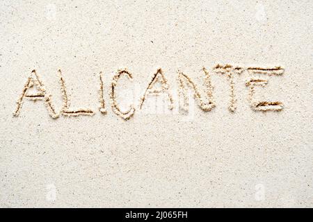 Handschriftliche Worte 'Alicante' auf Sand am Strand Stockfoto