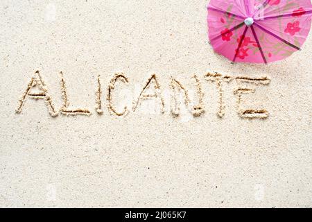 Handschriftliche Worte 'Alicante' auf Sand am Strand Stockfoto