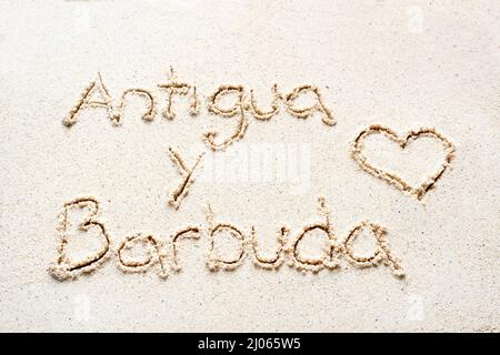 Handschriftliche Worte 'Antigua y barbuda' auf Sand am Strand Stockfoto