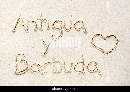 Handschriftliche Worte 'Antigua y barbuda' auf Sand am Strand Stockfoto