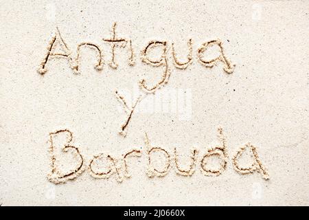 Handschriftliche Worte 'Antigua y barbuda' auf Sand am Strand Stockfoto