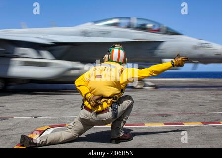 PHILIPPINE SEA (16. März 2022) LT. Caleb Derrington aus Batesville, Ark., leitet einen EA-18G Growler, der den 'Wizards' des Electronic Attack Squadron (VAQ) 133 zugewiesen wurde, um auf dem Flugdeck des Flugzeugträgers USS Abraham Lincoln (CVN 72) der Nimitz-Klasse zu starten. Die Abraham Lincoln Strike Group befindet sich im geplanten Einsatzgebiet der US-Flotte für 7., um die Interoperabilität durch Allianzen und Partnerschaften zu verbessern und gleichzeitig als reaktionsfähige Truppe zur Unterstützung einer freien und offenen Region im Indo-Pazifik-Raum zu dienen. (USA Navy Foto von Mass Communication Specialist Seaman Apprentice Julia Brockman) Stockfoto