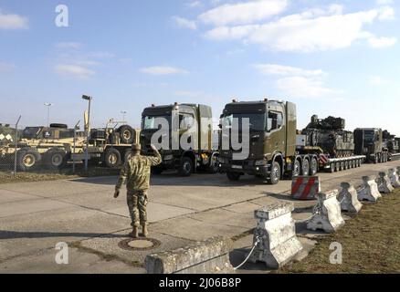 Die Bundeswehr Heavy Equipment Transport Systems (HETS) mit amerikanischen Bradley-Kampffahrzeugen (BFVs) erhalten grünes Licht und verlassen am 7. März 2022 die Coleman Barracks in Deutschland. Die Bundeswehr arbeitet Seite an Seite‐‐Seite mit amerikanischen Partnern, um das von der Armee vorpositionierte Aktienprogramm zu unterstützen, unsere Alliierten zu versichern und die russische Aggression abzuschrecken. (USA Foto der Armee von Staff Sgt. Jesse Pilgrim) Stockfoto