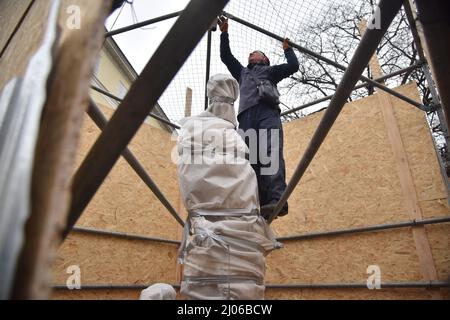 Lviv, Ukraine. 16. März 2022. Arbeiter schafft besonderen Schutz für den Brunnen mit der Statue der alten römischen Göttin Diana auf dem Rynok-Platz in Lemberg vor möglichen Bombardierungen der Stadt durch Russland. Seit 1998 ist das historische Zentrum von Lemberg UNESCO-Weltkulturerbe. Aufgrund der russischen Militärinvasion in die Ukraine und der Möglichkeit, die Stadt in Lemberg zu bombardieren, versuchen sie, historische Stätten zu schützen. (Foto von Pavlo Palamarchuk/SOPA Images/Sipa USA) Quelle: SIPA USA/Alamy Live News Stockfoto