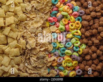 Verschiedene Vollkornfrühstücke - knusprige Pads, Müsli, fruchtige Maisringe und Schokoladenkugeln. Gesunde vegetarische und Babynahrung. Banner, Werbung. Stockfoto