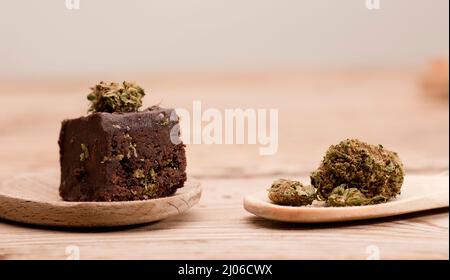 Schokoladen-Cupcake-Muffins mit Cannabisknospen. Marihuana Hanf medizinische Drogen in Lebensmitteln Dessert. Schokolade Kräuter Muffins Kochen. Marihuana-Kuchen auf einem braunen Stockfoto