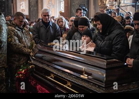 Lviv, Ukraine. 14. März 2022. Trauernde zollen drei gefallenen Soldaten ihren letzten Respekt. Die Trauernden zollen den drei gefallenen Soldaten, die beim russischen Luftangriff auf den Militärstützpunkt Javoriv am 13. März 2022 getötet wurden, ihren letzten Respekt. Lokale Behörden berichteten, dass 35 Menschen auf dem Stützpunkt, der sich in der Nähe der westlichen Grenze der Ukraine zu Polen befindet, getötet und 134 verletzt wurden. (Bild: © Laurel Chor/SOPA-Bilder über ZUMA Press Wire) Stockfoto