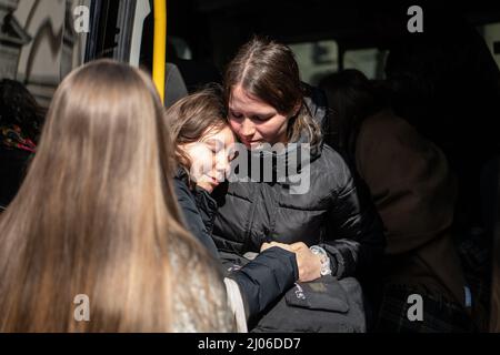 Lviv, Ukraine. 14. März 2022. Tanya Yashchyshyn (1. von R) wird nach dem Trauergottesdienst ihres Vaters, Oberst Oleg Yashchyshyn, von einer Freundin getröstet. Die Trauernden zollen den drei gefallenen Soldaten, die beim russischen Luftangriff auf den Militärstützpunkt Javoriv am 13. März 2022 getötet wurden, ihren letzten Respekt. Lokale Behörden berichteten, dass 35 Menschen auf dem Stützpunkt, der sich in der Nähe der westlichen Grenze der Ukraine zu Polen befindet, getötet und 134 verletzt wurden. (Bild: © Laurel Chor/SOPA-Bilder über ZUMA Press Wire) Stockfoto