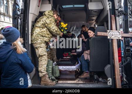 Lviv, Ukraine. 14. März 2022. Die Familie von Colonel Oleg Yashchyshy sitzt nach seinem Gedenkgottesdienst in einem Leichenwagen mit seiner Schatulle. Die Trauernden zollen den drei gefallenen Soldaten, die beim russischen Luftangriff auf den Militärstützpunkt Javoriv am 13. März 2022 getötet wurden, ihren letzten Respekt. Lokale Behörden berichteten, dass 35 Menschen auf dem Stützpunkt, der sich in der Nähe der westlichen Grenze der Ukraine zu Polen befindet, getötet und 134 verletzt wurden. (Bild: © Laurel Chor/SOPA-Bilder über ZUMA Press Wire) Stockfoto