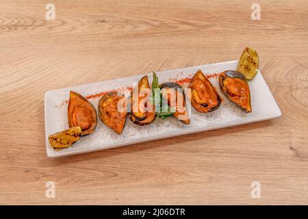 Die Kokosmilch, das Kuripulver, die Kikkoman natürlich fermentierte Sojasauce und den Zucker in eine Schüssel geben und vermischen. Zu den folgenden Muscheln Stockfoto