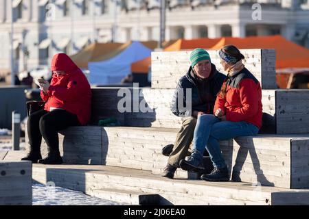 Helsinki, Finnland. 16. März 2022. Menschen sonnen sich auf einem Marktplatz in Helsinki, Finnland, 16. März 2022. Quelle: Matti Matikainen/Xinhua/Alamy Live News Stockfoto