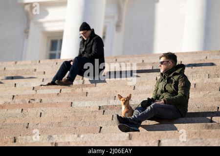 Helsinki, Finnland. 16. März 2022. Die Menschen sonnen sich an den Stufen der Kathedrale von Helsinki in Helsinki, Finnland, 16. März 2022. Quelle: Matti Matikainen/Xinhua/Alamy Live News Stockfoto