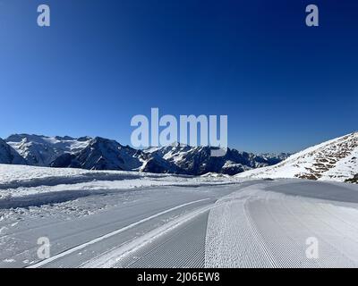 Winterlandschaft der Straße mit Bergen Hintergrund unter einem blauen Himmel Stockfoto
