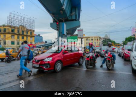 Verschwommenes Bild von Kalkutta, Westbengalen, Indien. Autos und Zivilisten, die unter der Überführung der AJC Bose-Straße vorbeifahren, belebter Stadtverkehr der Kolkata-Straße. Stockfoto