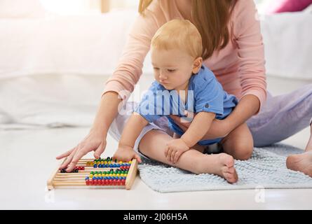 Mama und ihre Mini-Mathematikerin. Zugeschnittene Aufnahme einer Mutter und ihres kleinen Jungen, die auf einem Abakus zählen. Stockfoto