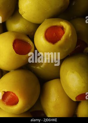 Makroaufnahme. Grüne gefüllte Oliven. Viele Objekte. Kochen, Snacks, Vitamine, Antioxidantien, Lebensmittel bereit zu essen. Restaurant, Hotel, Café, Werbung BU Stockfoto