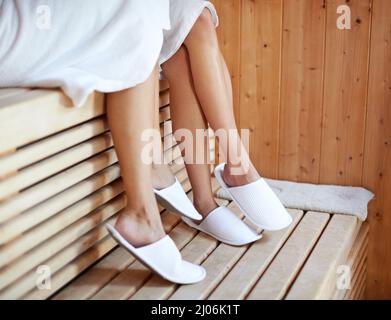 Gesellschaftssitzung in der Sauna. Zwei junge Frauen sitzen darin. Stockfoto