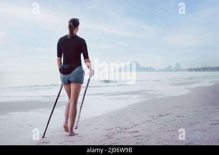 Frau, die am Strand wandert, verwischt die Bewegung. Aktiver und gesunder Lebensstil. Stockfoto