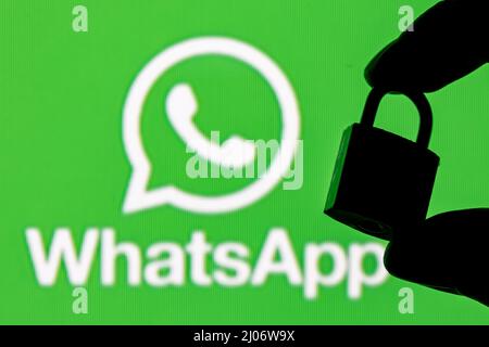 Das Icon der Whatsapp Messenger-Anwendung unter anderem auf dem Smartphone-Bildschirm. Auf dem Hintergrund ist das Whatsapp Logo zu sehen. Stockfoto