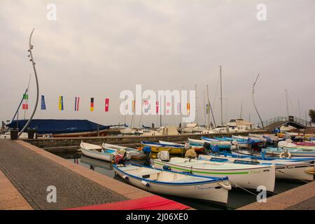 Bardolino, Italien - Dezember 27. 2021. Eine Anlegestelle und Boote an der Uferpromenade von Bardolino am Ostufer des Gardasees, Provinz Verona, Venetien Stockfoto