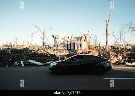 Mayfield, Usa. 13. Dez 2021. Ein Auto fährt am 11. Dezember an einem Haus vorbei, das von einem Tornado schwer beschädigt wurde. In Kentucky gibt es mindestens 74 Tote, nachdem vier Tornados während des Unwetterausbruchs letzte Woche im Bundesstaat niedergeschlagen wurden. (Foto: Matthew Hatcher/SOPA Images/Sipa USA) Quelle: SIPA USA/Alamy Live News Stockfoto