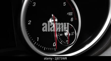 Auto-Tachometer mit glühenden roten Indikatoren Nahaufnahme, von Luxus-Armaturenbrett in Sportwagen Stockfoto