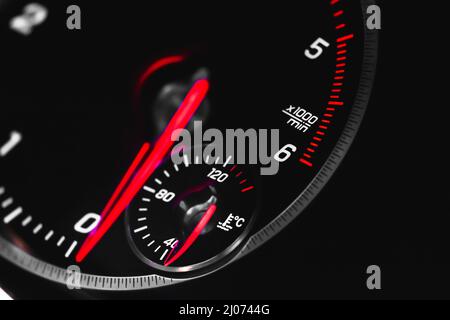 Auto-Tachometer mit glühenden roten Indikatoren Nahaufnahme, von Luxus-Armaturenbrett in Sportwagen Stockfoto