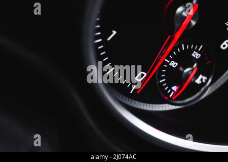 Auto-Tachometer mit glühenden roten Indikatoren Nahaufnahme, von Luxus-Armaturenbrett in Sportwagen Stockfoto