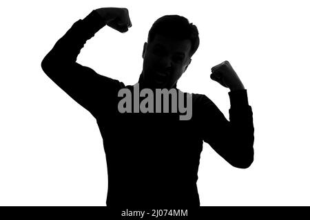 Mann zeigt Arme Muskeln lächelnd stolz. Fitness-Konzept. Silhouette Ansicht Stockfoto