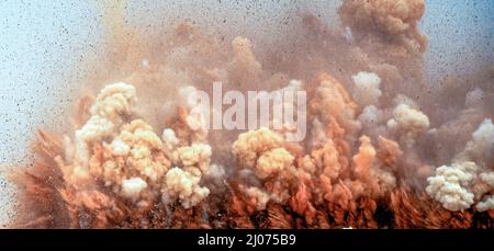 Fliegende Felsen- und Staubwolken nach dem Sprengen der Detonatoren in der Wüste Stockfoto