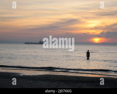 Diese spektakulären Skulpturen von Antony Gormley befinden sich am Crosby Beach, in der Nähe von Liverpool, England, Großbritannien. Ein anderer Ort besteht aus 100 gusseisernen, lebensgroßen Figuren, die sich über drei Kilometer des Vorhores erstrecken und sich fast einen Kilometer bis zum Meer erstrecken. Die jeweils 650 Kilo schweren Figuren des Another Place bestehen aus Abgüssen des eigenen Körpers, der am Strand steht, alle mit Blick aufs Meer und in stiller Erwartung auf den Horizont starrend. Stockfoto