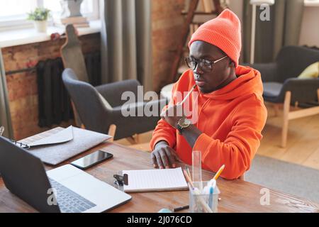 Aufnahme eines modernen afroamerikanischen Studenten in stilvollem, legerem Outfit mit Online-Kursen während des Lockdown Stockfoto