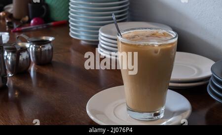 Frisch zubereiteter Eisfrapuccino mit Eiswürfeln auf einem Holztisch in einem Café in tulum mexiko Stockfoto