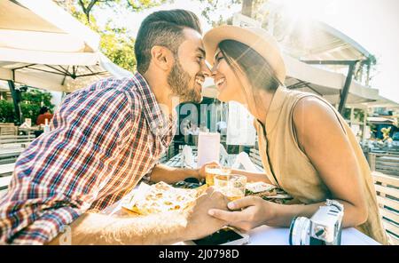 Verliebte Pärchen küssen sich an der Bar und essen lokale Delikatessen auf einem Ausflug - Junge glückliche Touristen genießen Momente im Street Food Restaurant - Relationsh