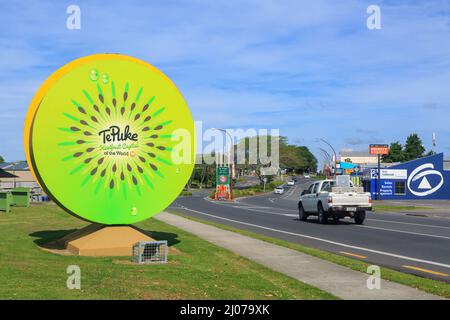 Ein Willkommensschild in Form einer riesigen Kiwifruit-Scheibe am Stadtrand von Te Puke, Neuseeland Stockfoto