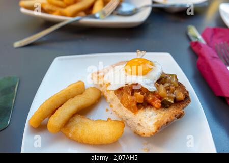 Spanische Eier und Chips mit Brot Stockfoto