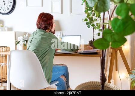 Freiberufliche Frau, die von zu Hause aus am Laptop arbeitet. Stockfoto