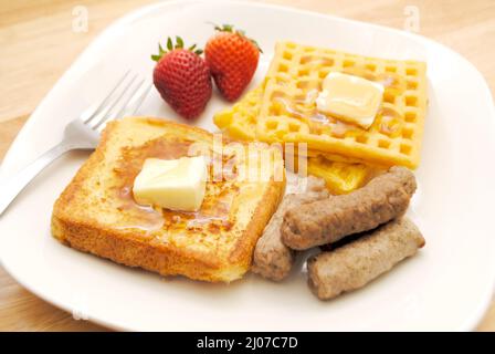 Französischer Toast, Waffeln und zwei Schweinewurst-Links auf einem weißen Teller Stockfoto
