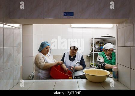 BEREHOVE, UKRAINE - 16. MÄRZ 2022 - Frauen kochen in der Küche des Gabriel Bethlen Berehove Lyzeums, das intern Vertriebene beherbergt, Bereh Stockfoto