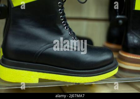 Schwarze Schuhe mit gelben Sohlen. Details der Magie der Schuhe. Damenschuhe auf der Vitrine. Stockfoto